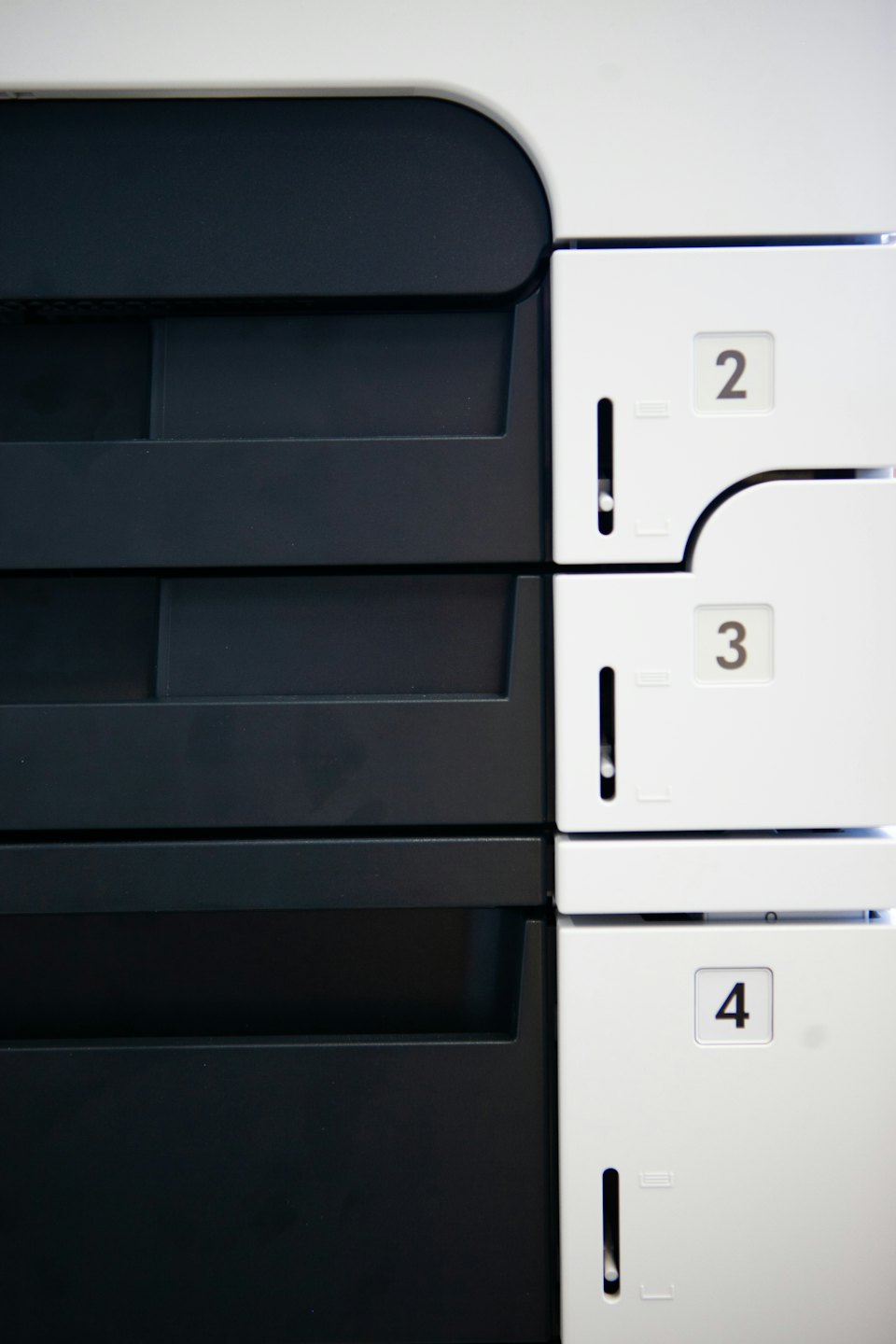 Stampante multifunzione da ufficio moderna con cassetti carta numerati.